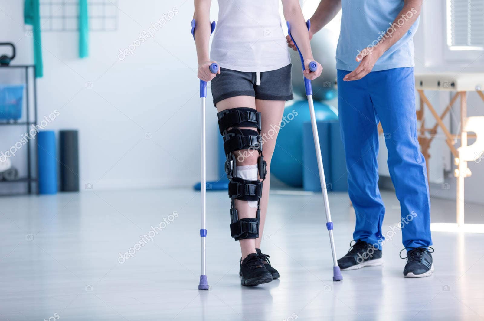 sport physiotherapist and patient with leg injury during trainin