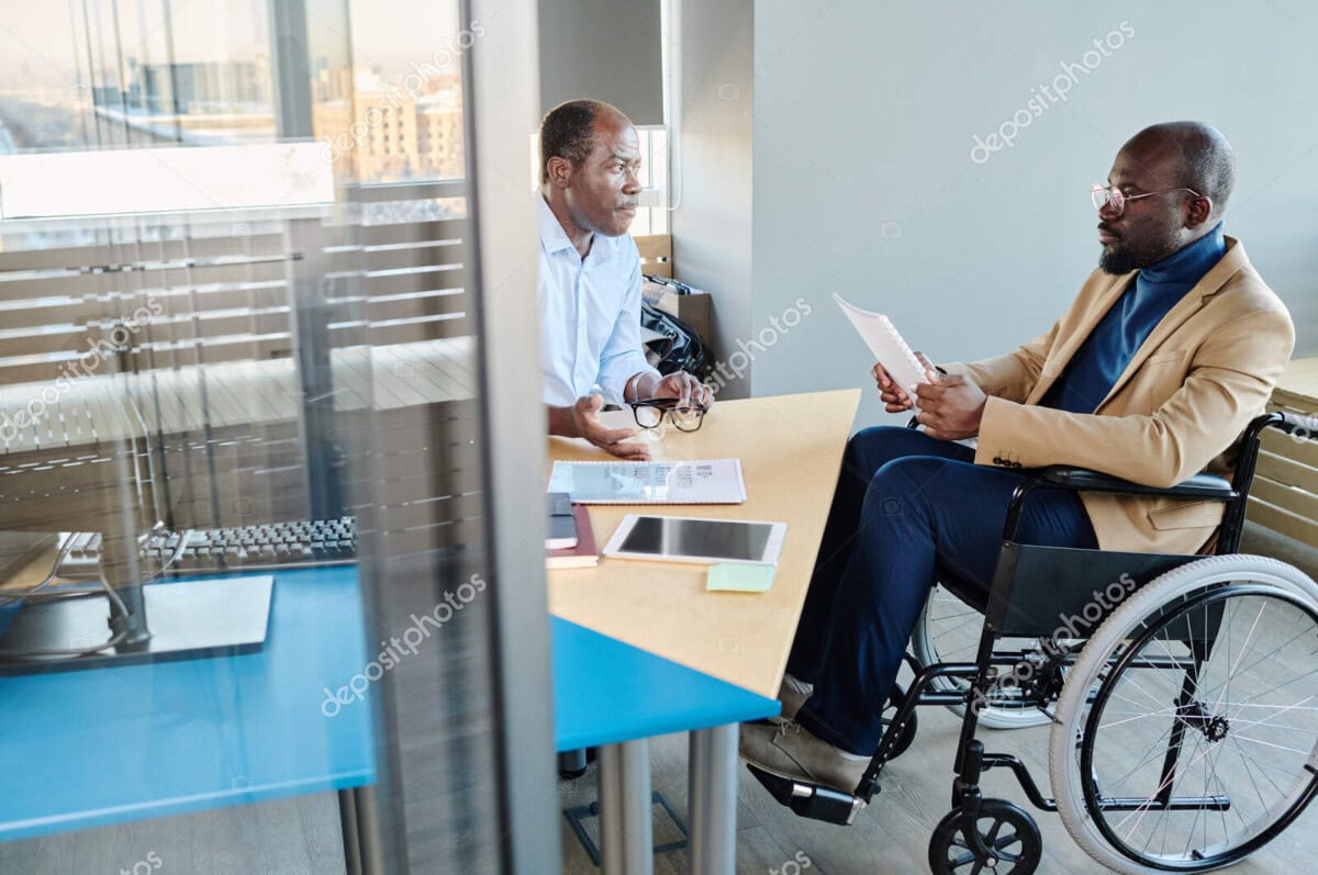confident boss listening to report of his subordinate in wheelchair